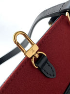 Louis Vuitton strap detail with gold lock clasp on red felt-like lining