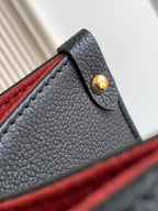 Louis Vuitton bag corner detail with gold snap stud on textured black leather
