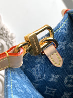Louis Vuitton denim tote bag close-up of gold rings and strap hardware