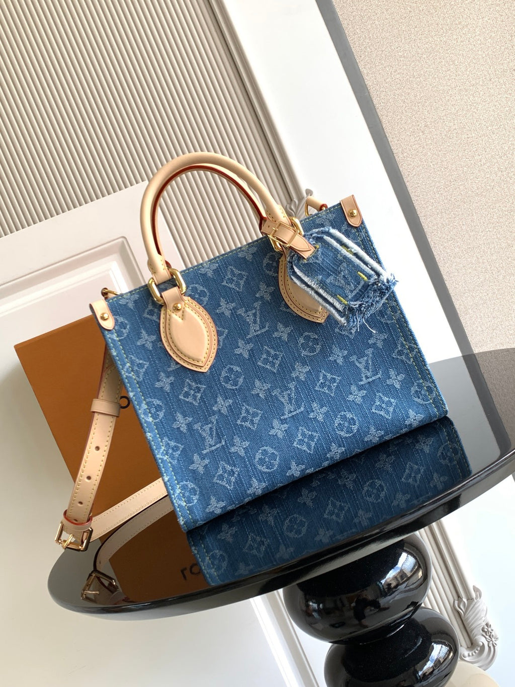 Louis Vuitton denim tote bag with dual top handles and gold-tone hardware