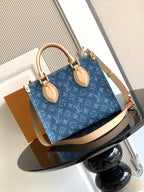 Louis Vuitton denim tote bag with top handles and tan leather trim