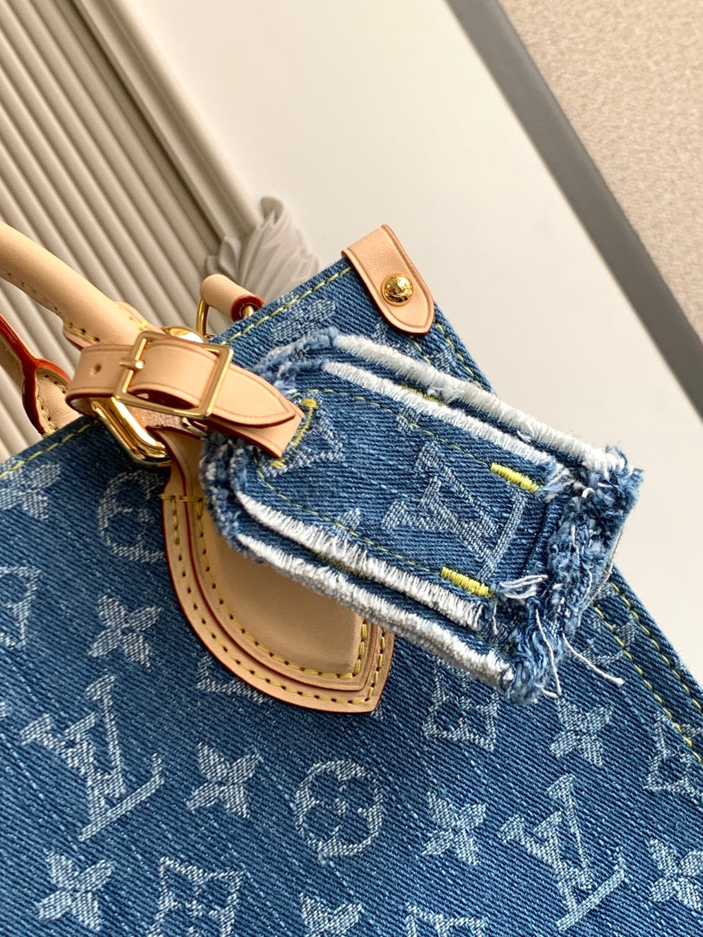 Louis Vuitton denim tote bag close-up of logo pattern, top handle and clasp