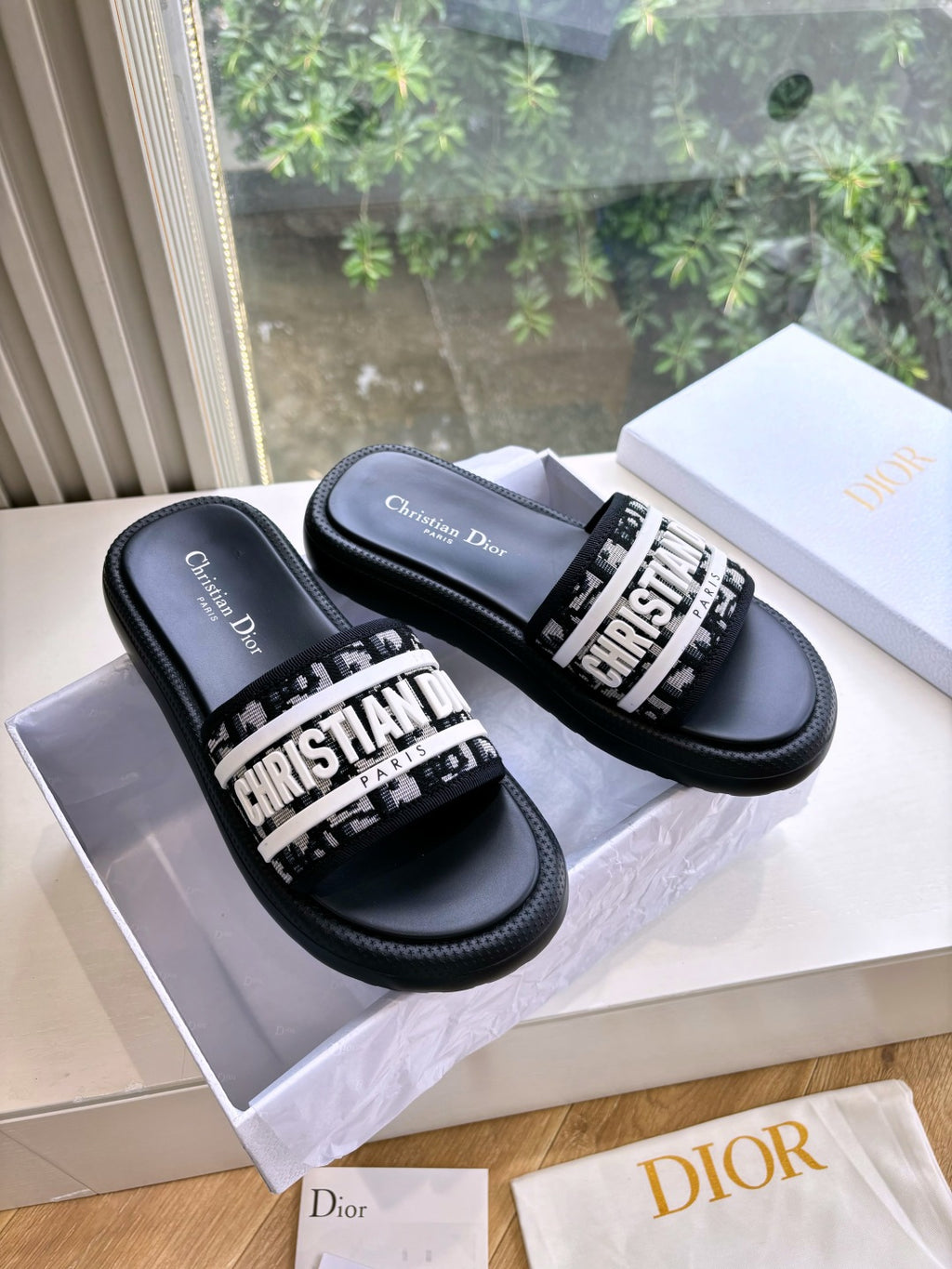 Black Dior slide sandals with white logo band and padded footbed