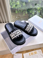 Black Dior slide sandals with white logo band and padded footbed