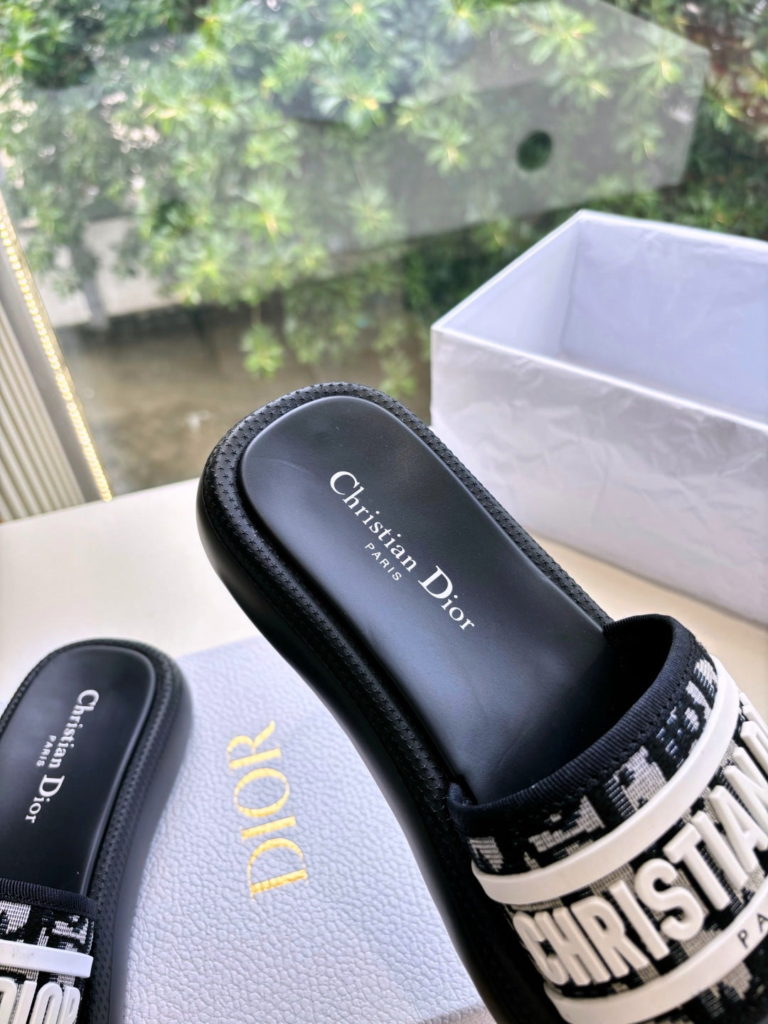 Black Dior slide sandal with white logo band and Christian Dior printed footbed