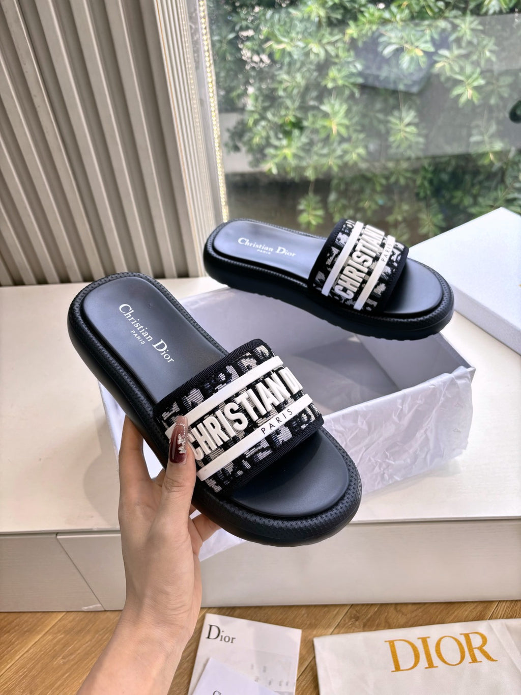 Black Dior slide sandals with white logo band, side view