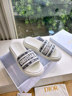 White Dior slide sandals with logo strap and textured rubber sole