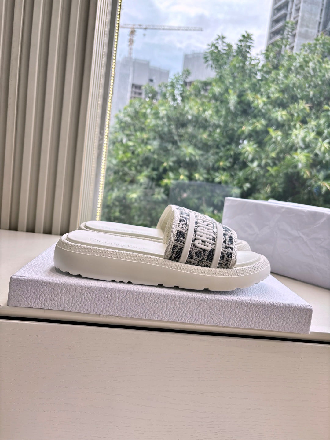 White Dior slide sandal with black logo strap and chunky sole