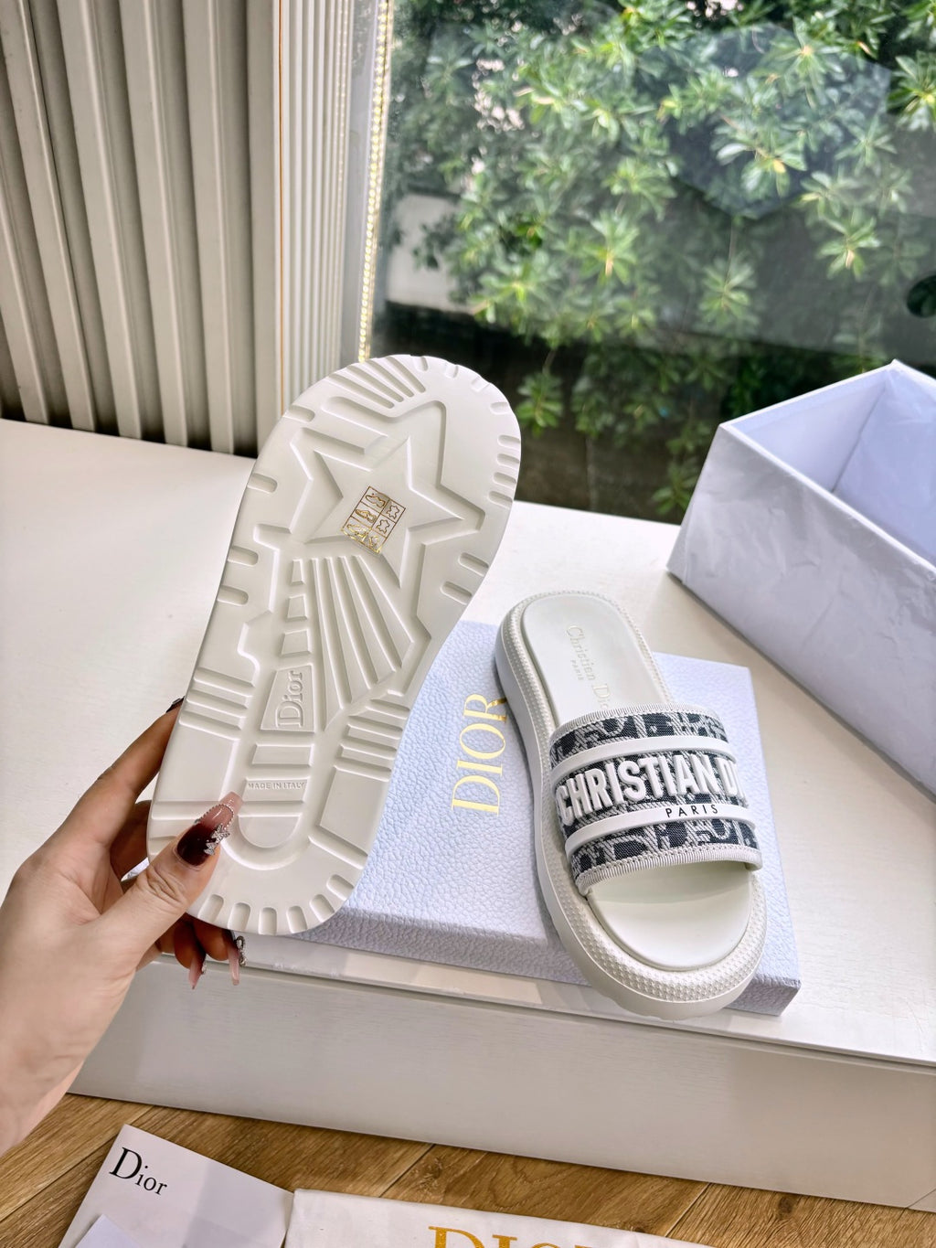 White Dior slide sandals with star pattern outsole and logo strap