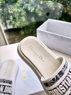 White Dior slide sandals, interior view of printed footbed and logo strap