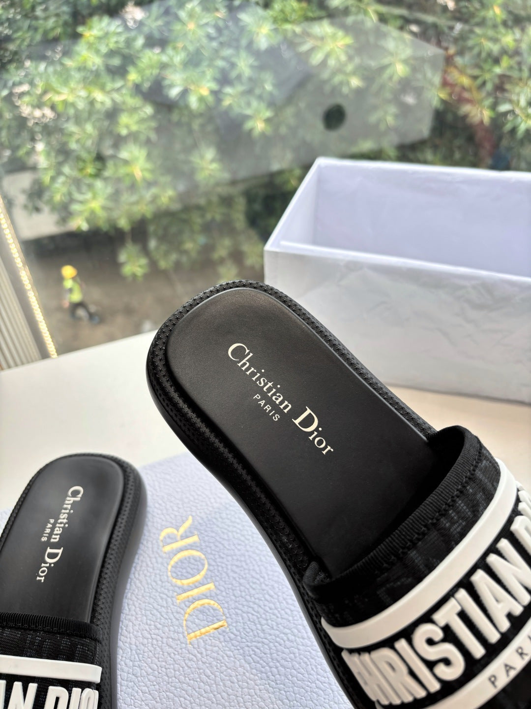 Black slide sandal with embossed "Christian Dior" logo on footbed