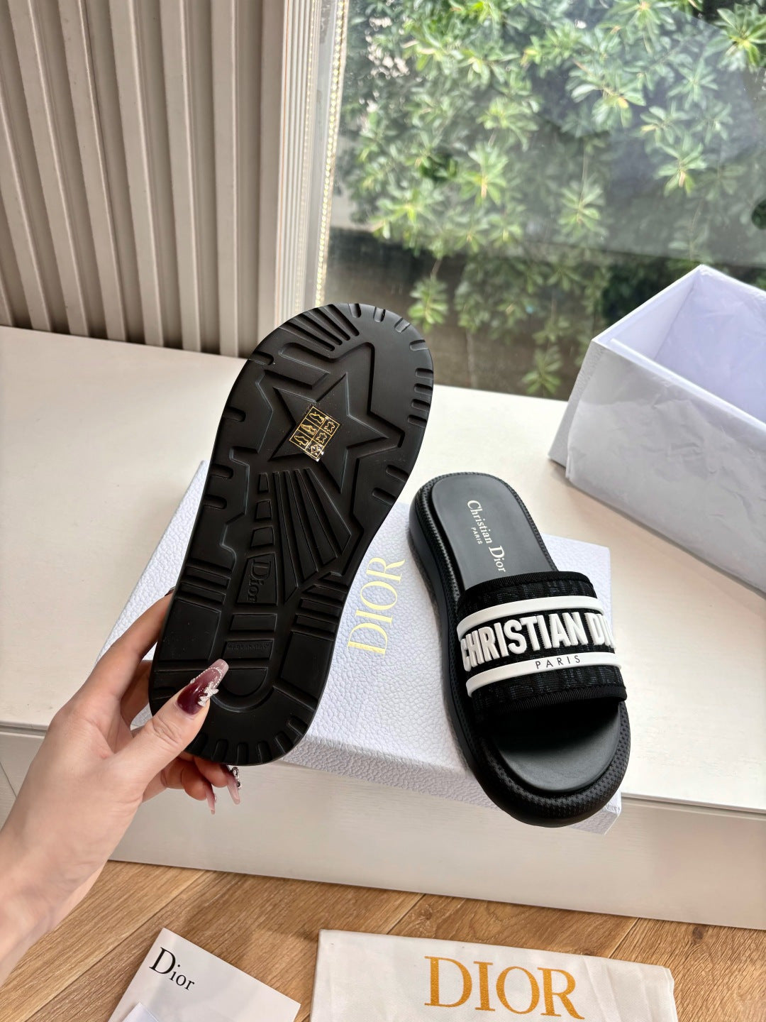Black slide sandals showing textured outsole and logo strap