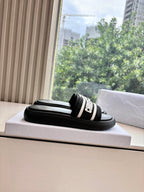 Black slide sandals with white side stripe and thick strap