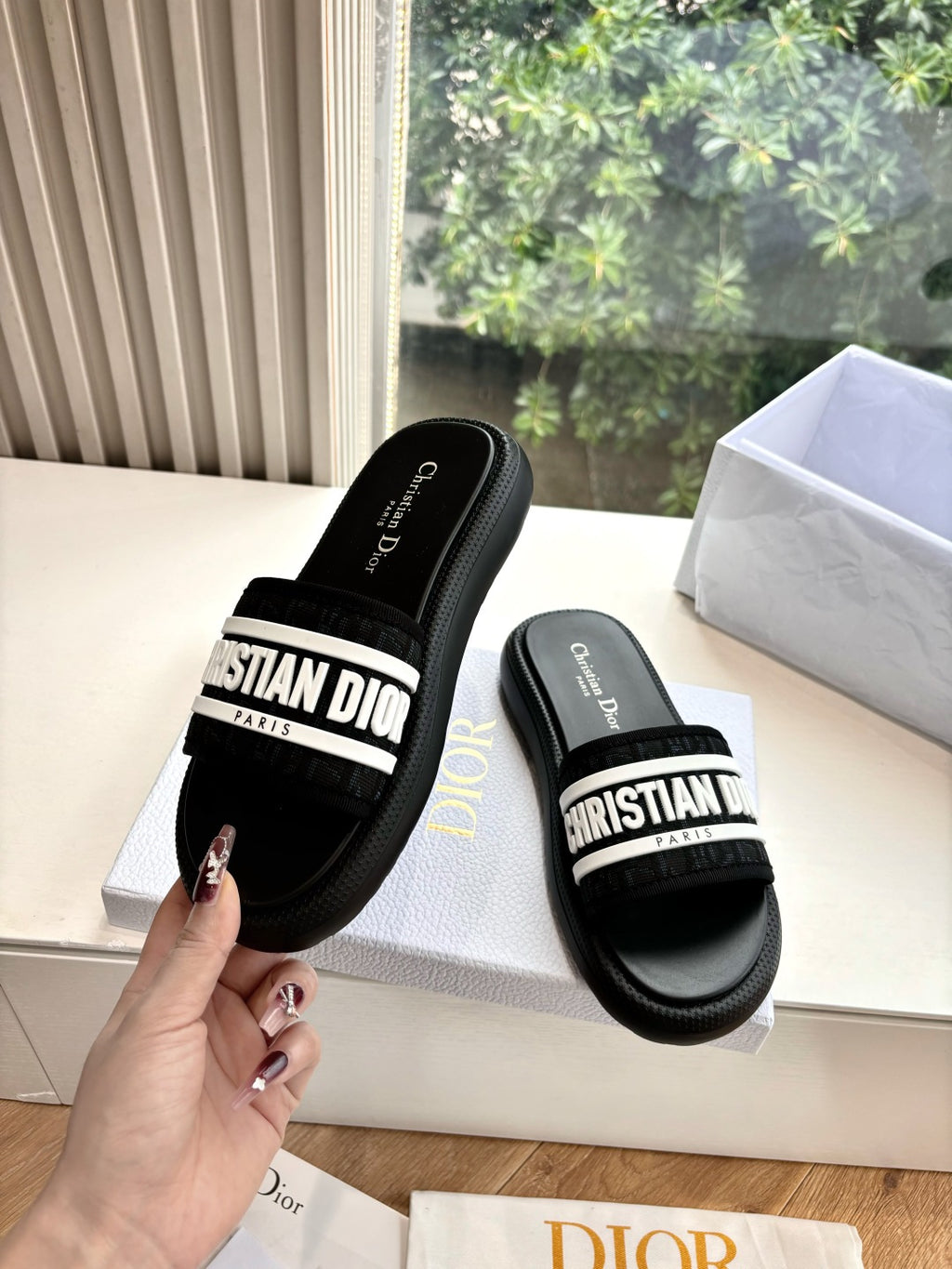 Black slide sandals with white logo strap and contoured black sole