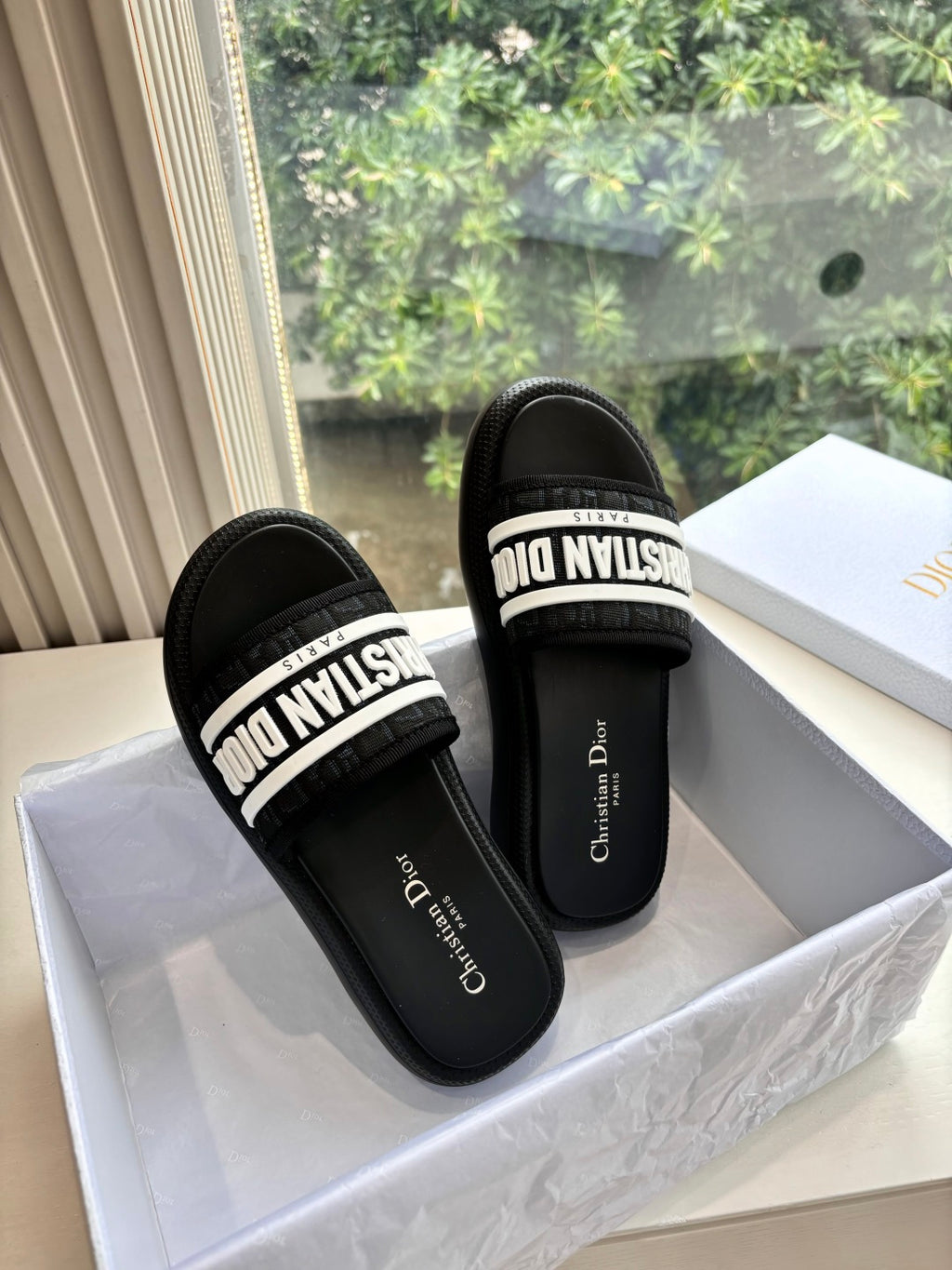 Black slide sandals with white logo strap and cushioned footbed
