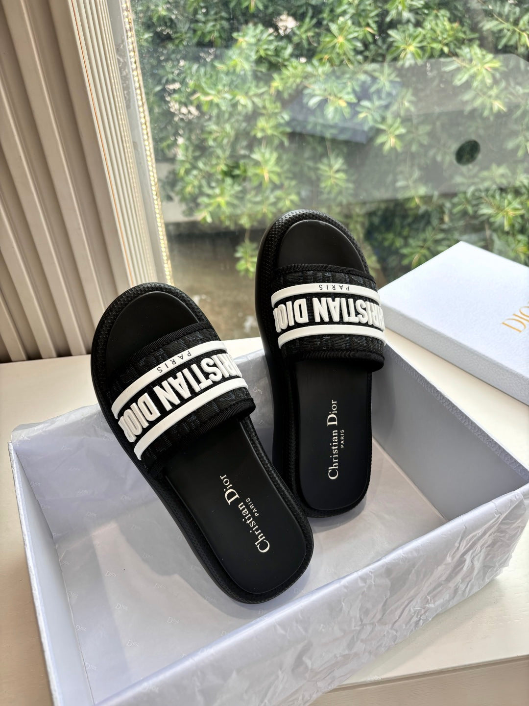 Black slide sandals with white logo strap and cushioned footbed