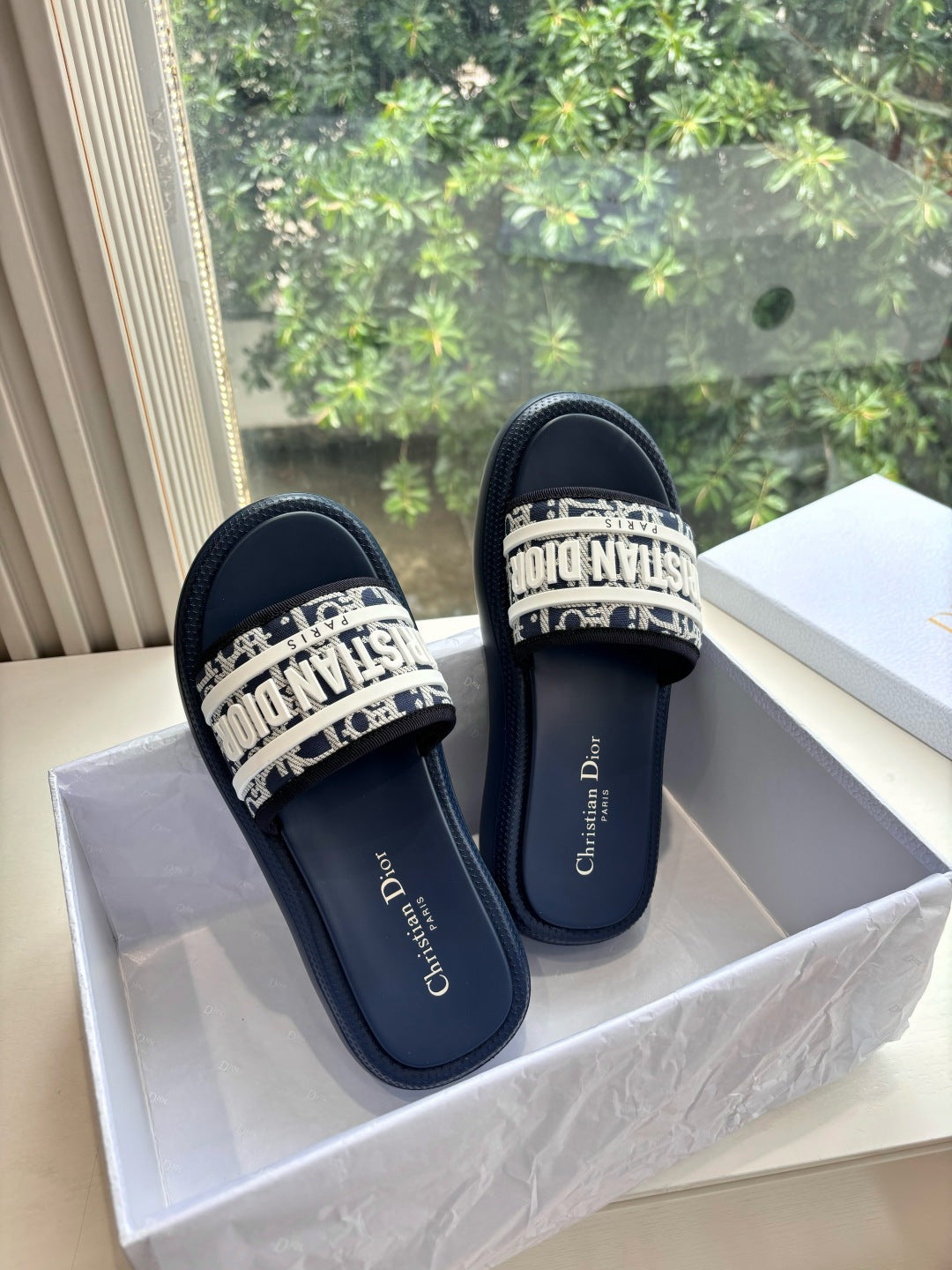 Women’s slide sandals pair, dark leather with patterned band across top