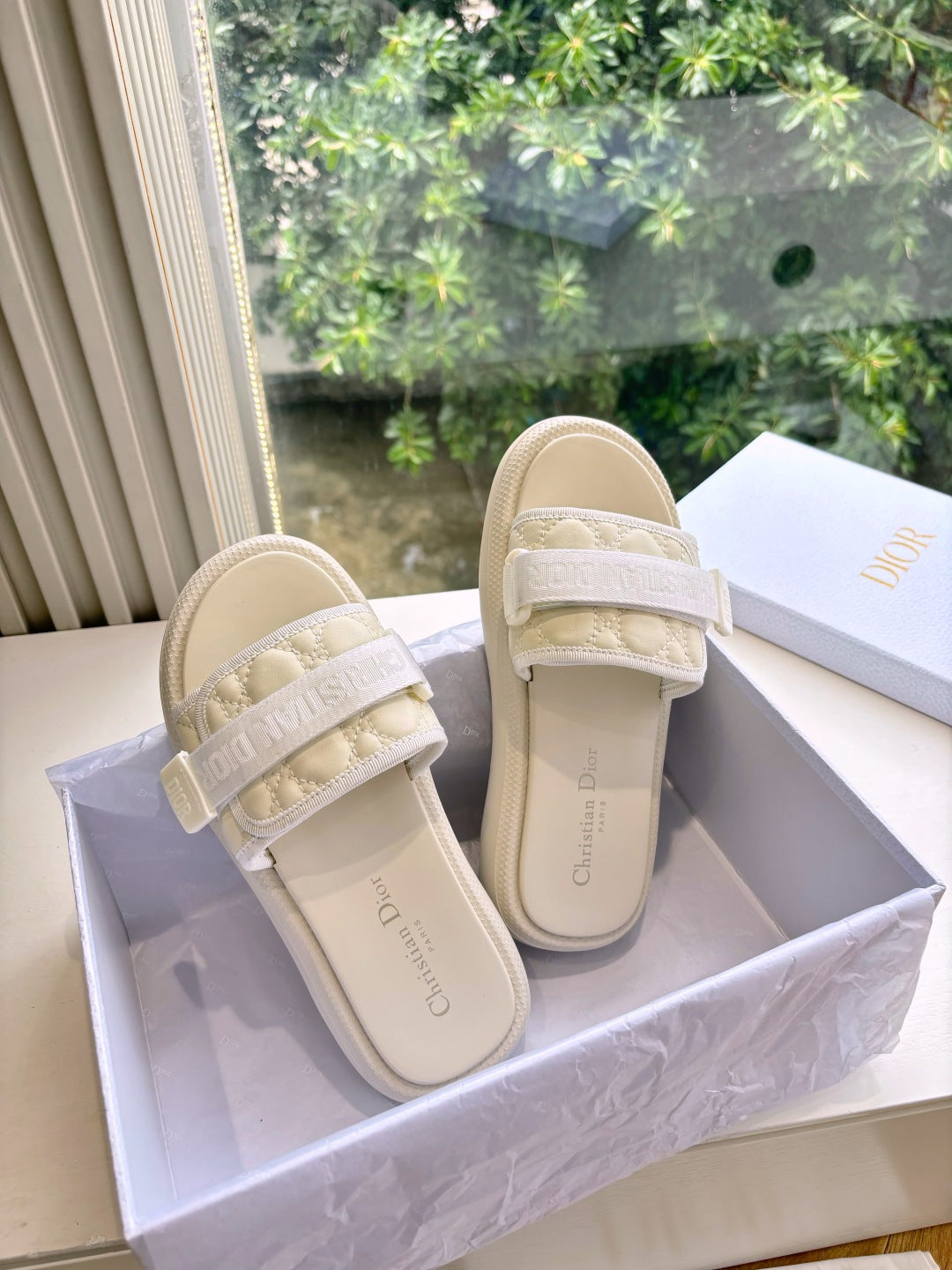 Dior ladies slide sandals, light beige, side view; cushioned strap with embossed lettering