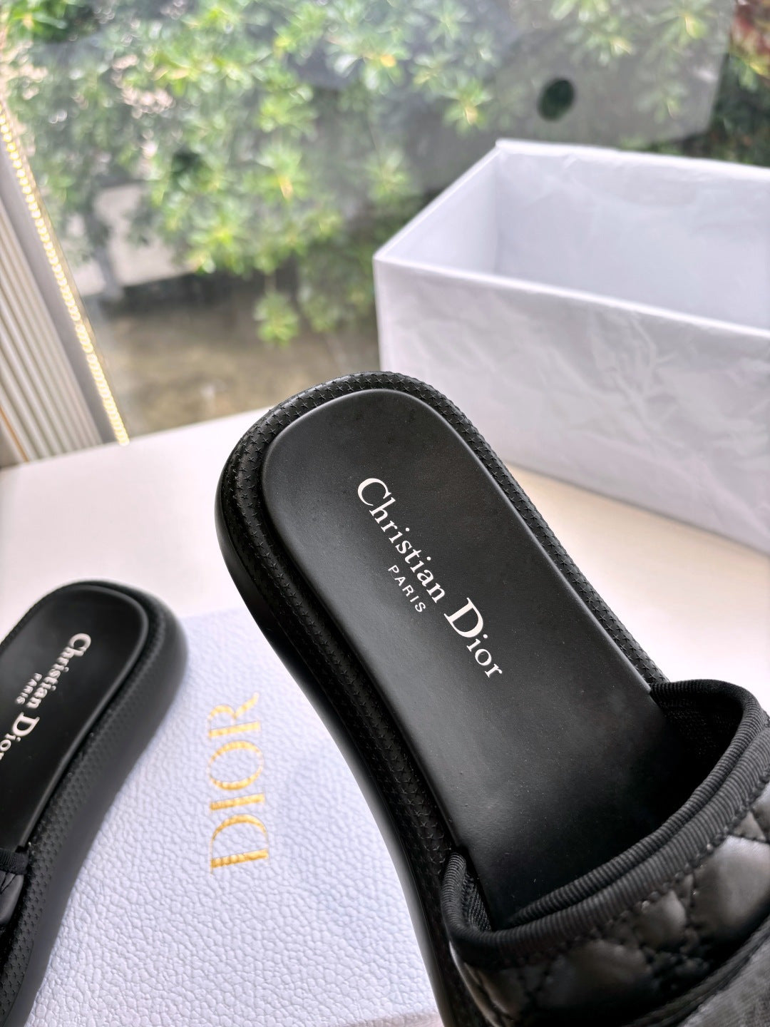 Black slide sandal footbed with “Christian Dior” logo, shown close-up with strap top