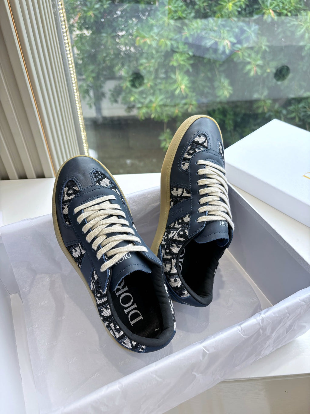 Navy low-top lace-up sneakers with logo pattern and off-white woven laces