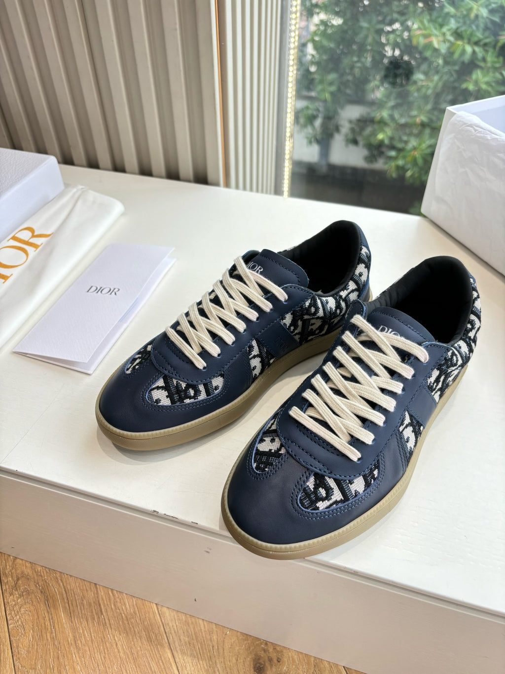 Navy low-top lace-up sneakers with logo panels and off-white laces
