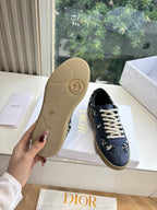 Shoe outsole view: navy low-top sneakers with tan rubber sole
