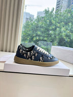 Navy low-top lace-up sneakers with logo print panels and gum-toned sole