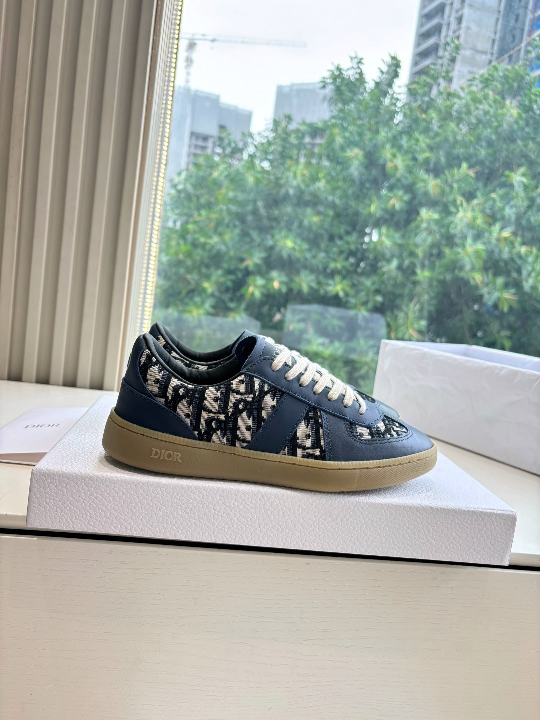 Navy low-top lace-up sneakers with logo print panels and gum-toned sole