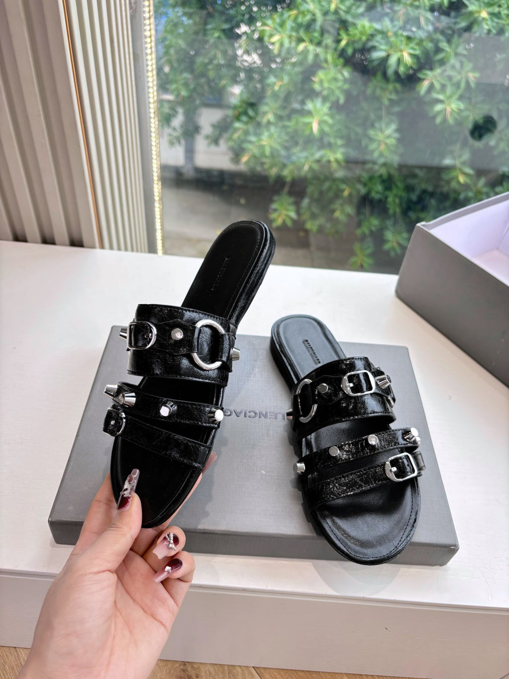 Black slide sandals with stacked straps, silver buckle hardware, side view