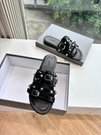 Black slide sandal with two buckled straps and studded detailing, side view
