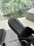 Black slide sandal close-up of textured footbed and strap buckle hardware