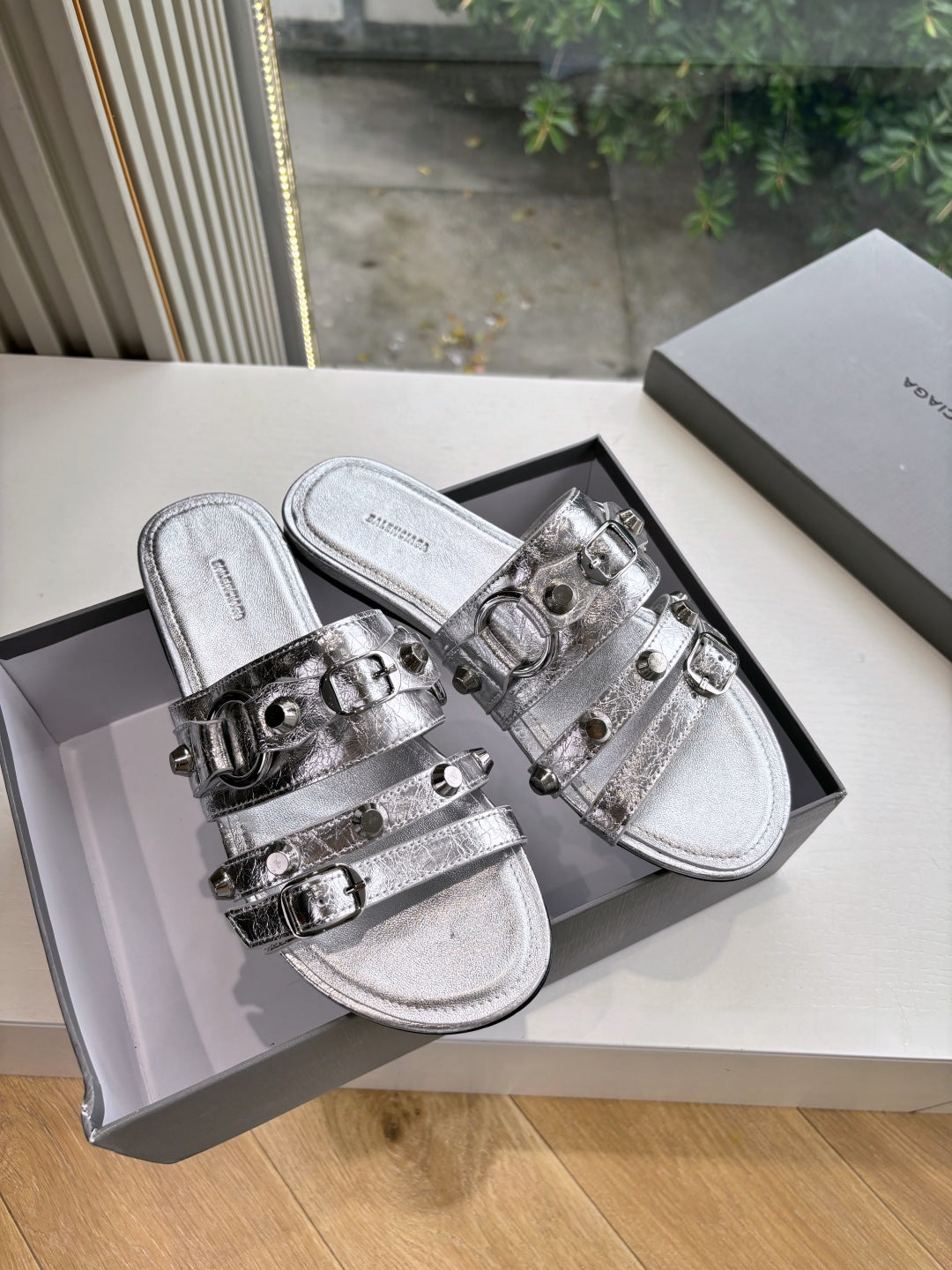 Metallic silver slide sandals with double buckle straps and squared toe