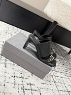 Black heeled sandals in open-toe slide style with gold buckle strap