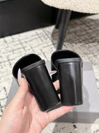 Pair of black slide sandals with thick block heels and wide strap openings