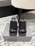 Black leather slide sandals with wide straps and gold buckle, block heel