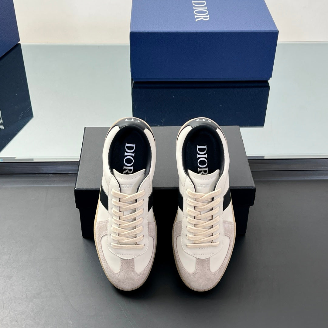 Pair of low-top sneakers with white uppers, navy heel, and lace-up front