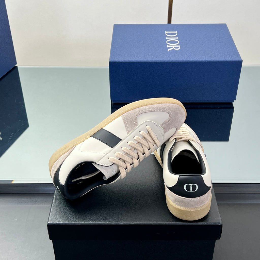 Close side view of white low-top sneakers with navy stripe and cream sole