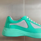 Prada unisex sneaker side view, mint green leather with gray mesh panel and white stitching