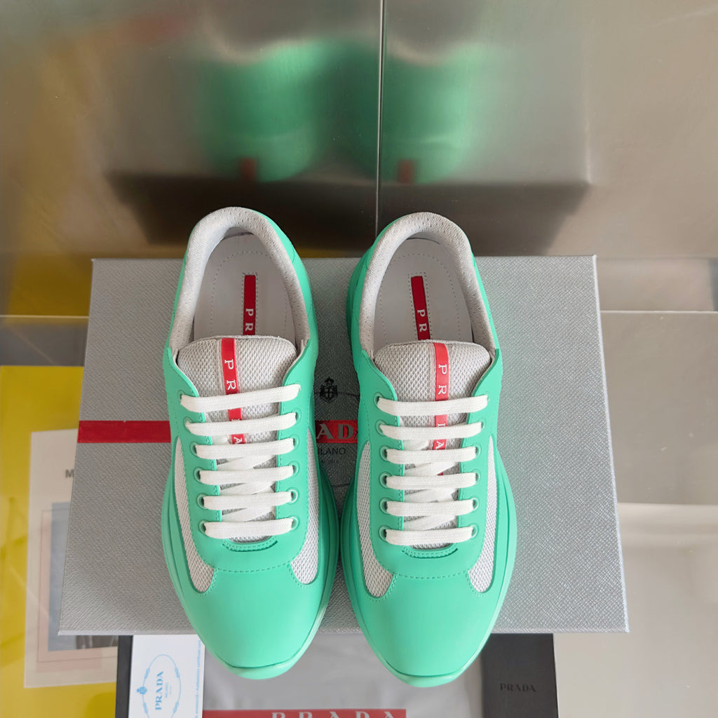 Pair of Prada unisex mint green sneakers with white laces and gray mesh toe and sides