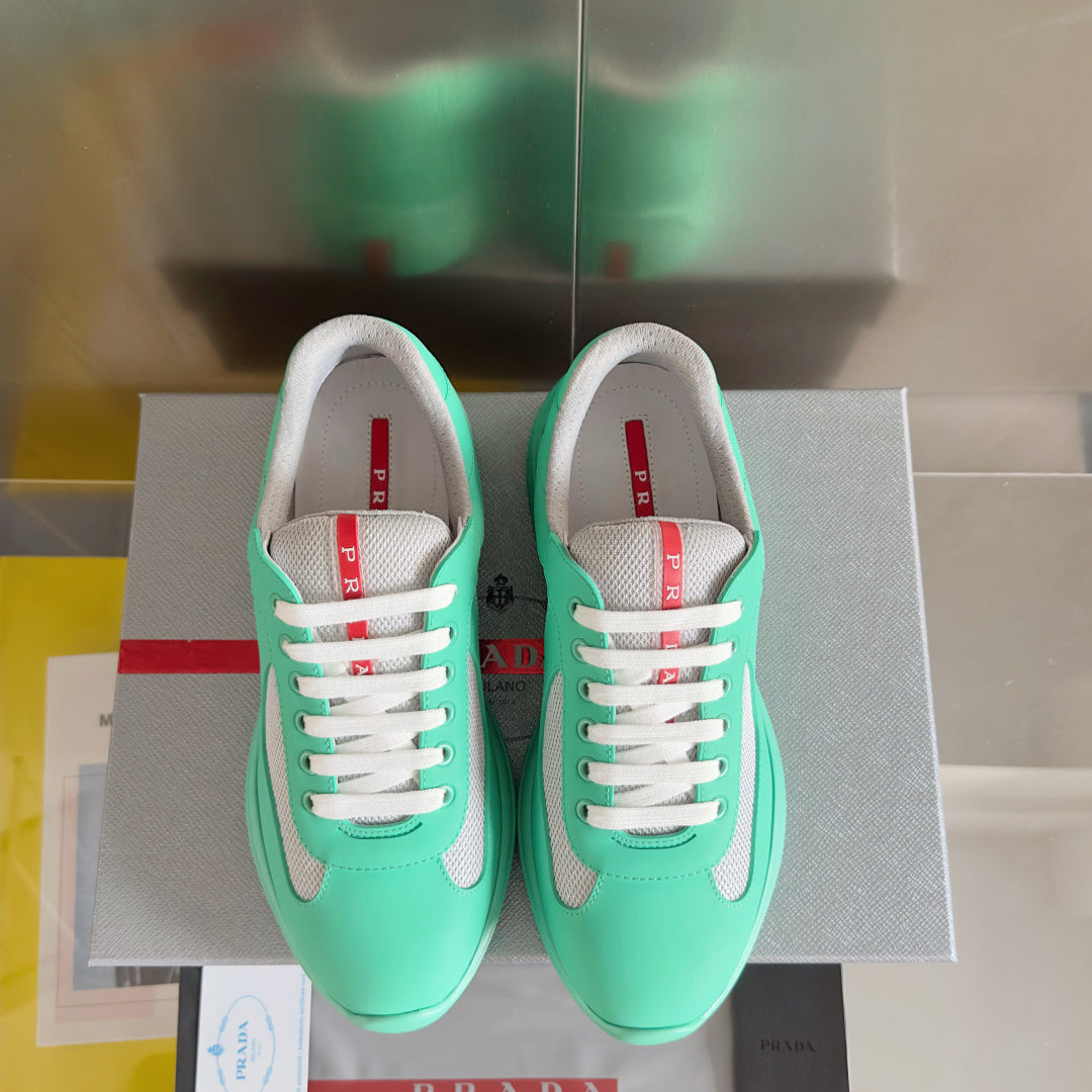 Pair of Prada unisex mint green sneakers with white laces and gray mesh toe and sides