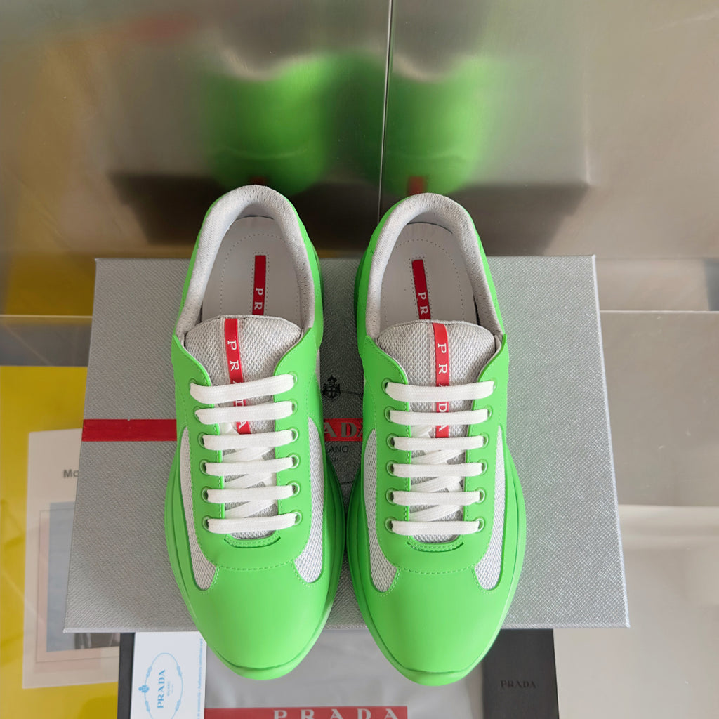 Prada unisex sneakers, neon green with gray toe caps, white laces, and red logo tab