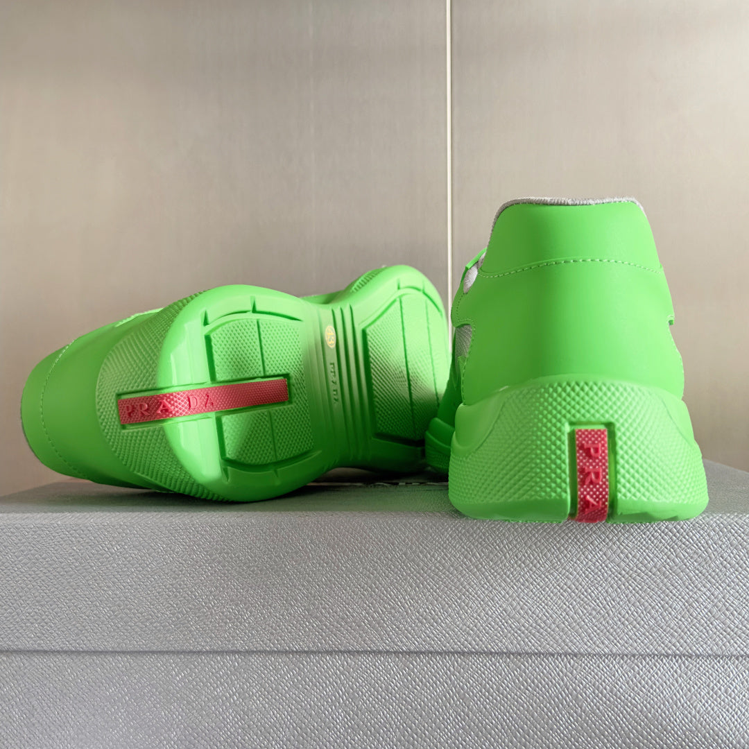 Prada unisex sneakers outsole view, neon green with red logo label at heel