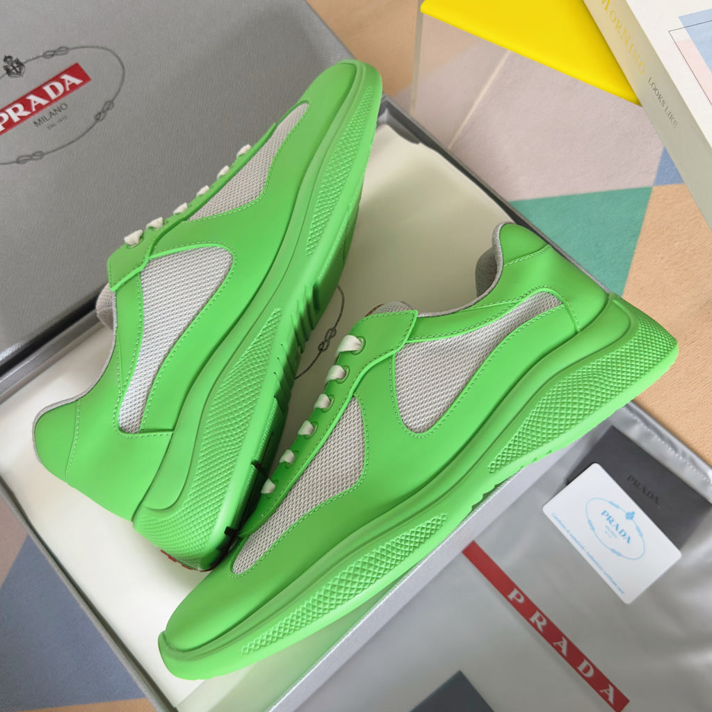 Pair of Prada unisex sneakers in neon green with gray mesh inserts and white lace-up