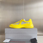 Yellow low-top sneakers with white mesh upper and lace-up front