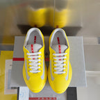 Pair of yellow low-top sneakers with white mesh uppers and lace-up fronts