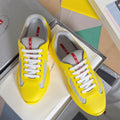 Yellow low-top sneakers with white mesh panels and lace-up front