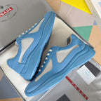 Prada unisex sneakers on box, light blue with textured sole and white lace eyelets