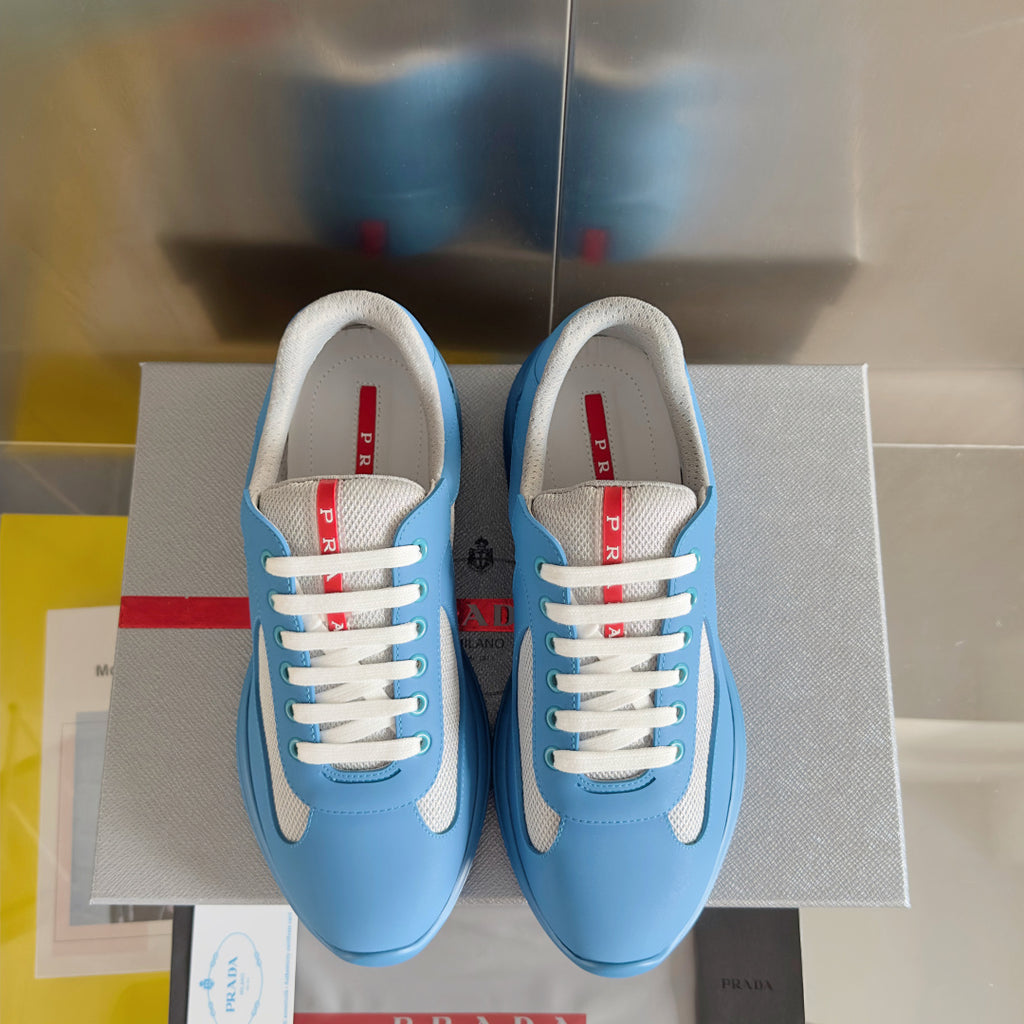 Prada unisex sneakers pair, light blue with white laces and padded gray collars