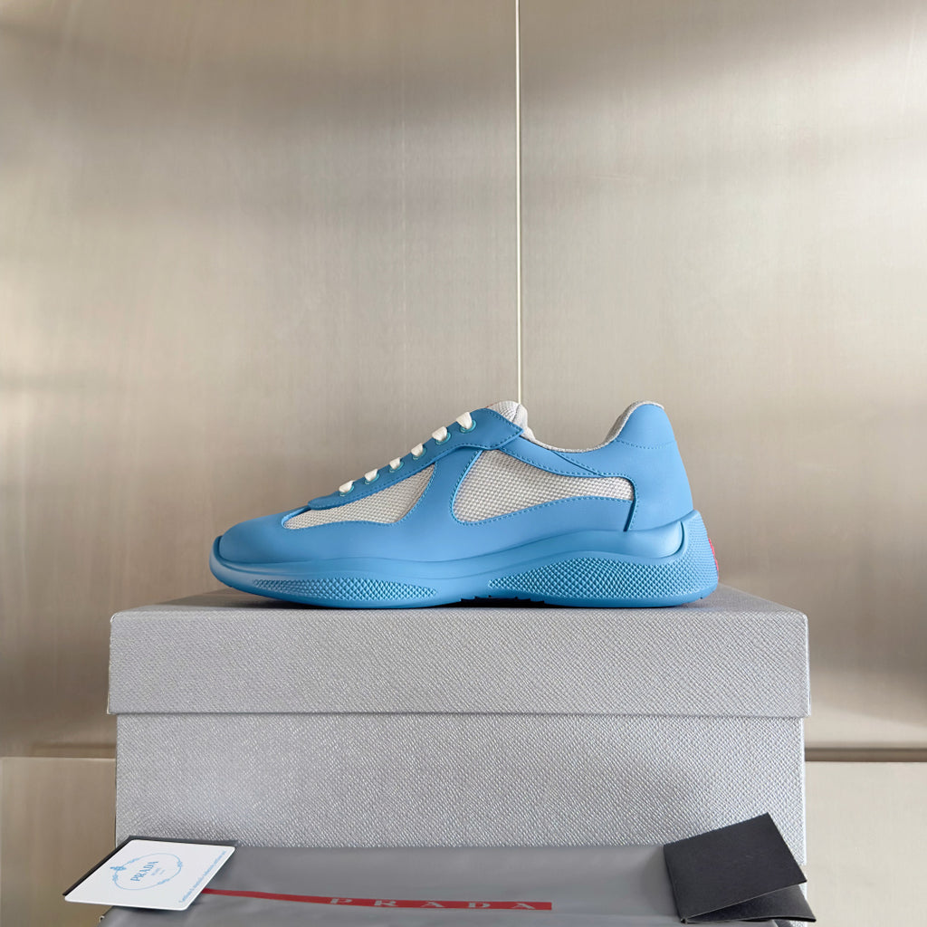 Prada unisex sneakers in light blue with white lace trim and breathable mesh inserts