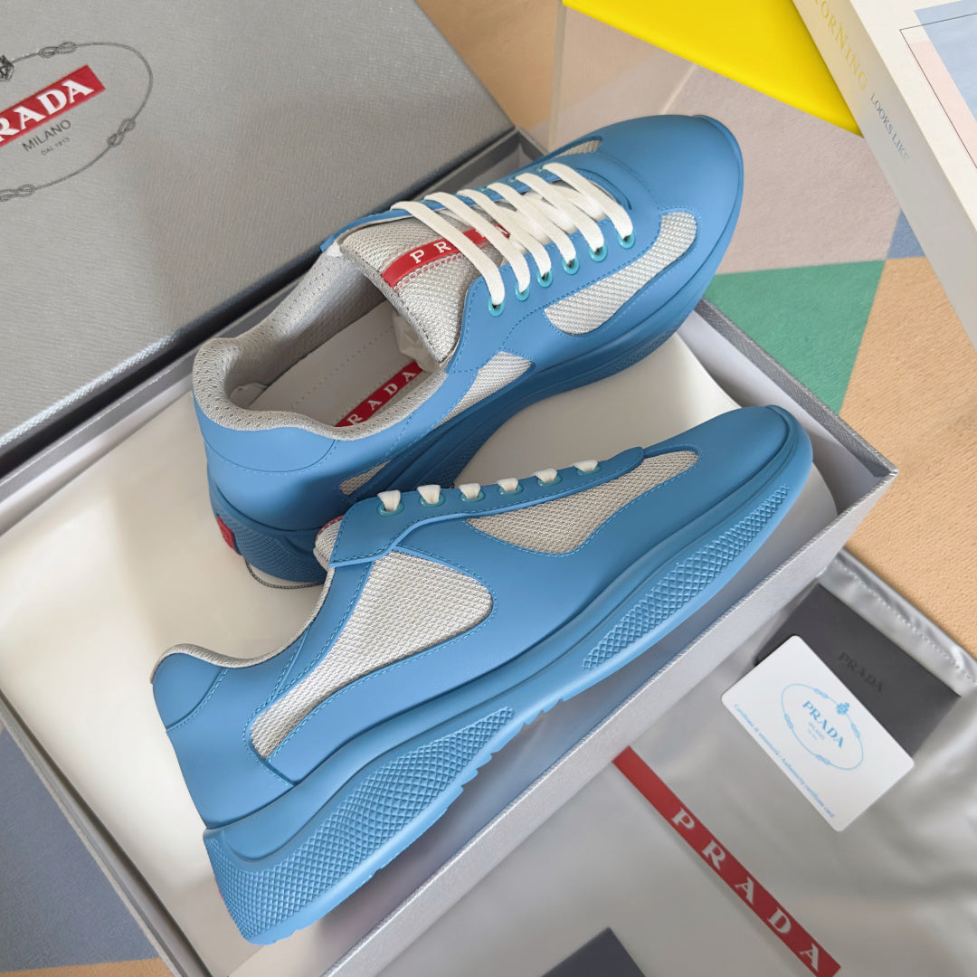 Prada unisex sneakers on shoebox, light blue leather with white laces and gray panels